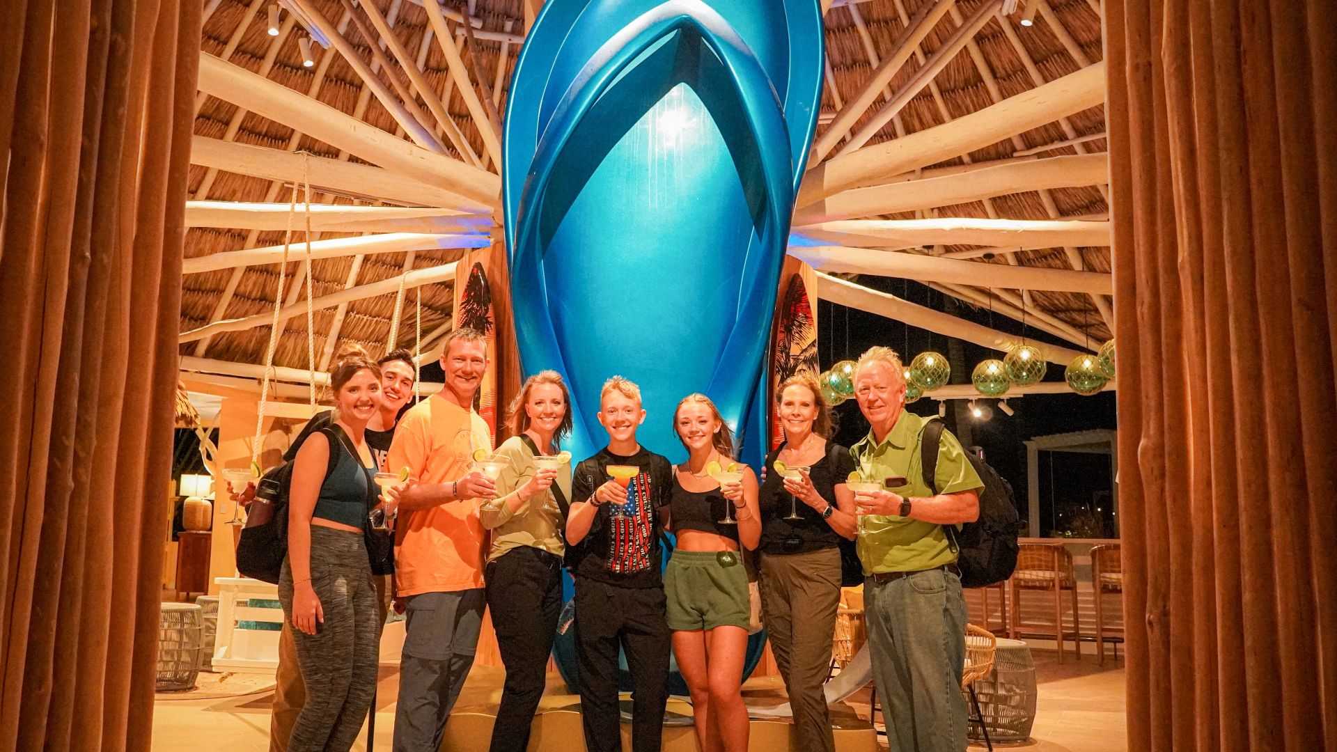 A Group Of People Posing For A Photo In Front Of A Large Blue Balloon