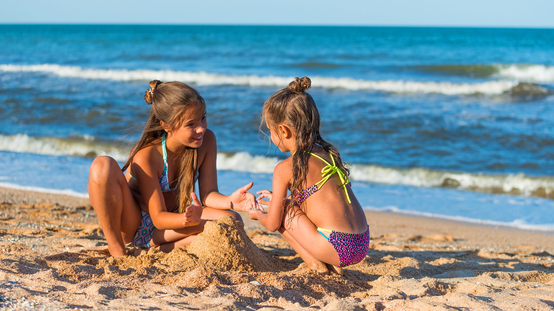 Two Girls Sitting On A Beach