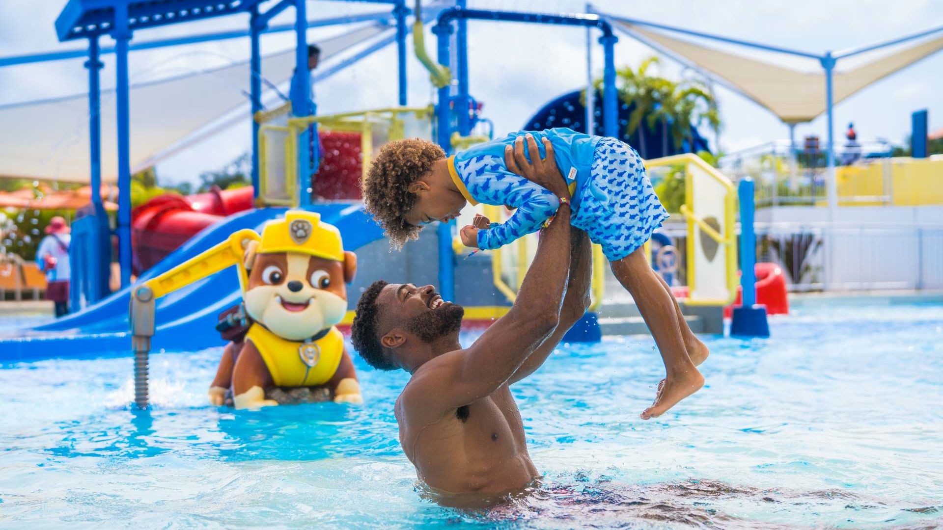 A Person And A Child In A Pool With A Toy In The Water