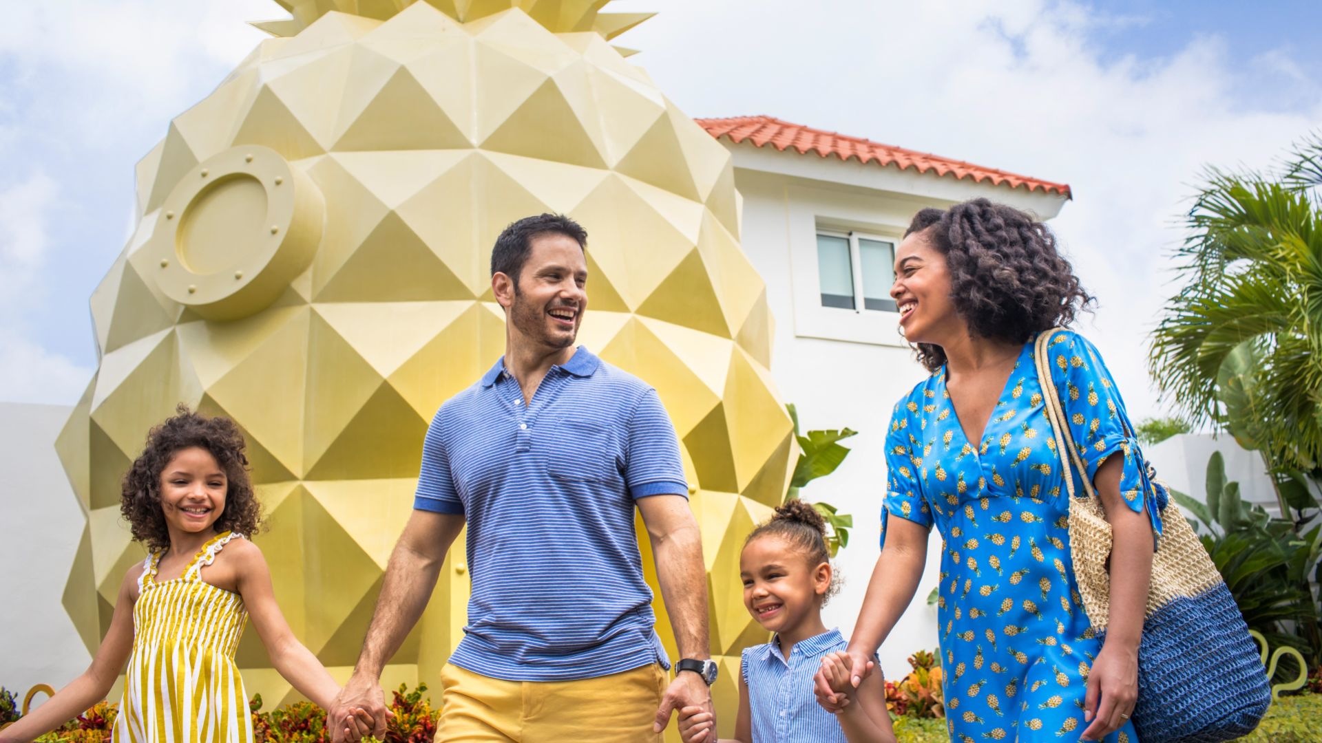 A Family Posing In Front Of A Large Yellow And White Tent