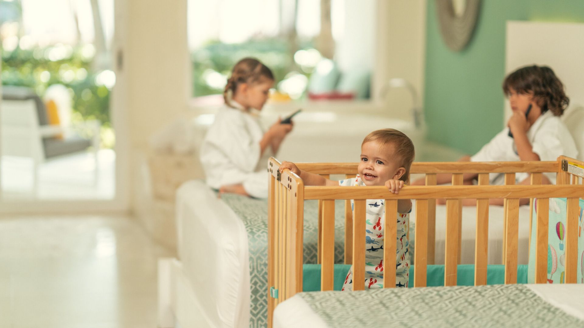 A Baby Sitting In A Crib